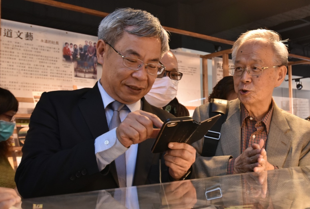 陳憲仁老師(右)向與會來賓陳益源教授(左)介紹展區之展品 陳憲仁老師(右)向與會來賓陳益源教授(左)介紹展區之展品